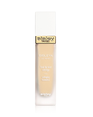 Sisley Paris Sisleya Le Teint Anti-Aging Foundation in a sleek glass bottle with a gold and white cap, featuring a light beige liquid inside for a natural finish.