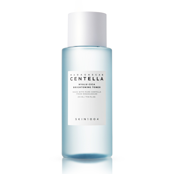 Clear glass bottle with a light blue liquid, featuring a white cap and a minimalist label that reads "Centella Hyalu-Cica Brightening Toner" by Skin1004, 210ml.