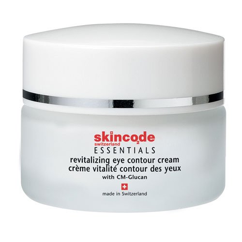 White jar with a silver band, labeled "Skincode Essentials Revitalizing Eye Contour Cream 15ml," featuring a clean design and Swiss flag emblem on the bottom.