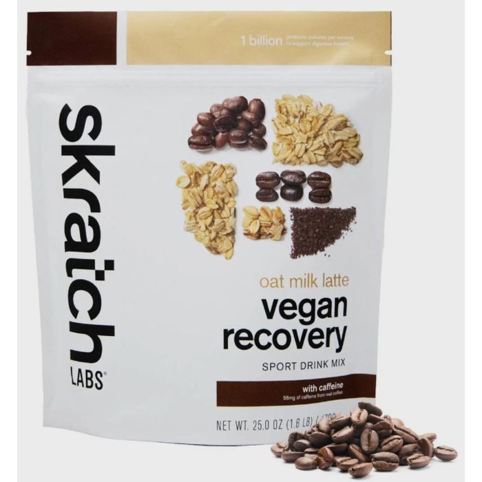 Skratch Labs Vegan Recovery Drink in Oat Milk Latte flavor, featuring a white pouch with black text, images of oats, coffee beans, and a pile of coffee grounds.