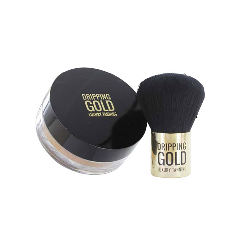 Loose bronzing powder in a clear jar with a black lid, labeled "DRIPPING GOLD," accompanied by a soft black brush with a gold handle.