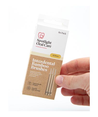 Interdental bamboo brushes in a cardboard packaging, featuring a natural color scheme, labeled "Spotlight Oral Care," and designed for effective oral hygiene.