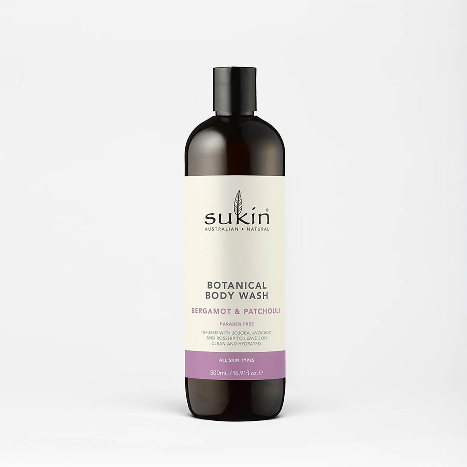 Dark brown bottle with a black cap, featuring a cream label that reads "Sukin Botanical Body Wash - Bergamot and Patchouli" in black and purple text, 500ml size, suitable for all skin types.