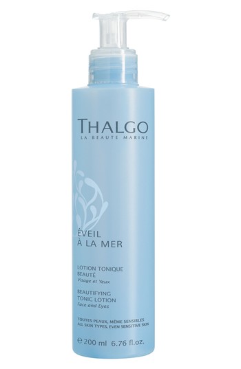 Light blue, cylindrical bottle with a pump dispenser, labeled "Thalgo Éveil à La Mer Beautifying Tonic Lotion" in white text, 200ml size, suitable for all skin types.