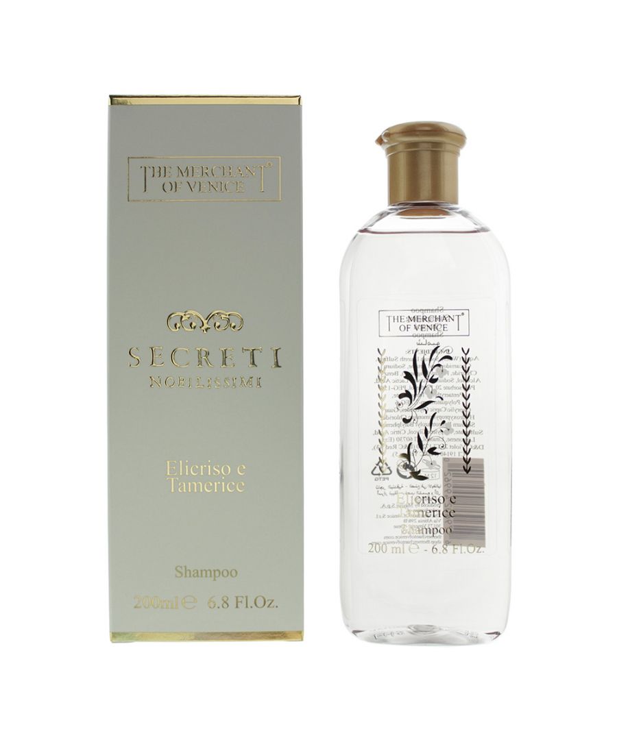 Clear bottle of "Helichrysum and Tamarisk Nourishing Hair Shampoo" with a gold cap, featuring elegant botanical illustrations, placed beside a decorative silver box.