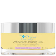 Clear glass jar with a yellow label reading "Antioxidant Cleansing Jelly" from The Organic Pharmacy, featuring a sleek design and a silver lid, suitable for all skin types.