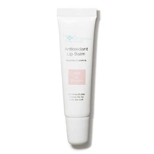 White tube of Antioxidant Lip Balm by The Organic Pharmacy, featuring a soft pink label, highlighting key ingredients like shea butter and rose hip oil, 7ml size.