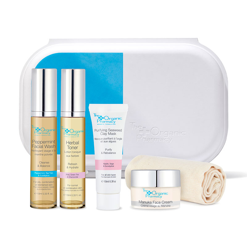 Clear skincare set featuring five products: Peppermint Facial Wash, Herbal Toner, Purifying Seaweed Clay Mask, Manuka Face Cream, and a cloth, all in a sleek white case with blue accents.