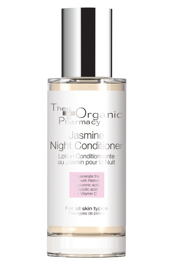 Clear glass bottle with a silver pump, containing a light yellow conditioner labeled "Jasmine Night Conditioner" by The Organic Pharmacy, featuring key ingredients like Retinol and Vitamin C.