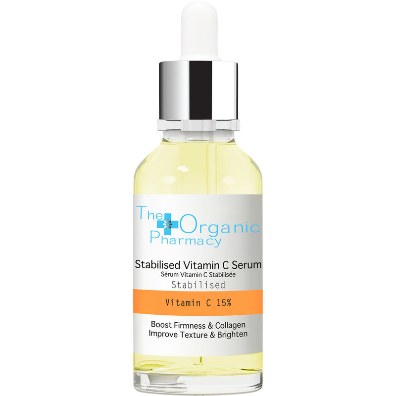 Clear glass bottle with a dropper, filled with a yellow serum labeled "Stabilised Vitamin C Serum" by The Organic Pharmacy, highlighting 15% Vitamin C for skin benefits.