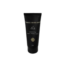 Black tube packaging with gold accents, labeled "Three Warriors Natural Gradual Tan," featuring a minimalist design and a flip-top cap, 150ml size.