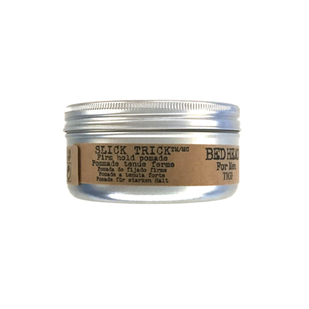 Silver metal tin with a screw-top lid, labeled "Slick Trick Firm Hold Pomade" in black and brown text, featuring a 2.65 oz capacity, designed for men's hairstyling.