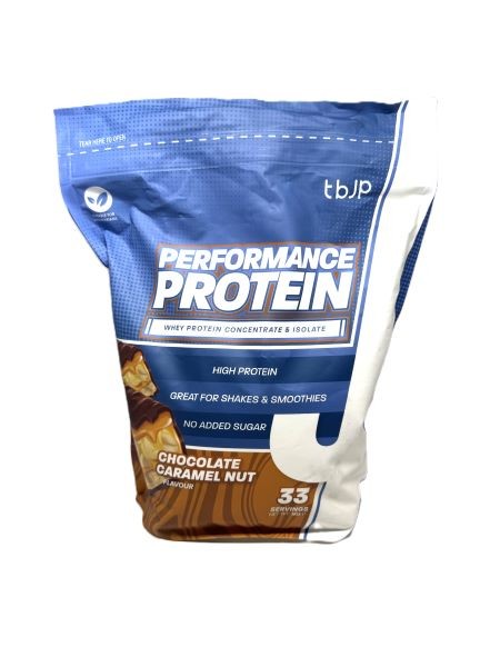 Blue and white bag of "Trained by JP Performance Protein" in chocolate caramel nut flavor, featuring a bold label and indicating 33 servings with high protein content.