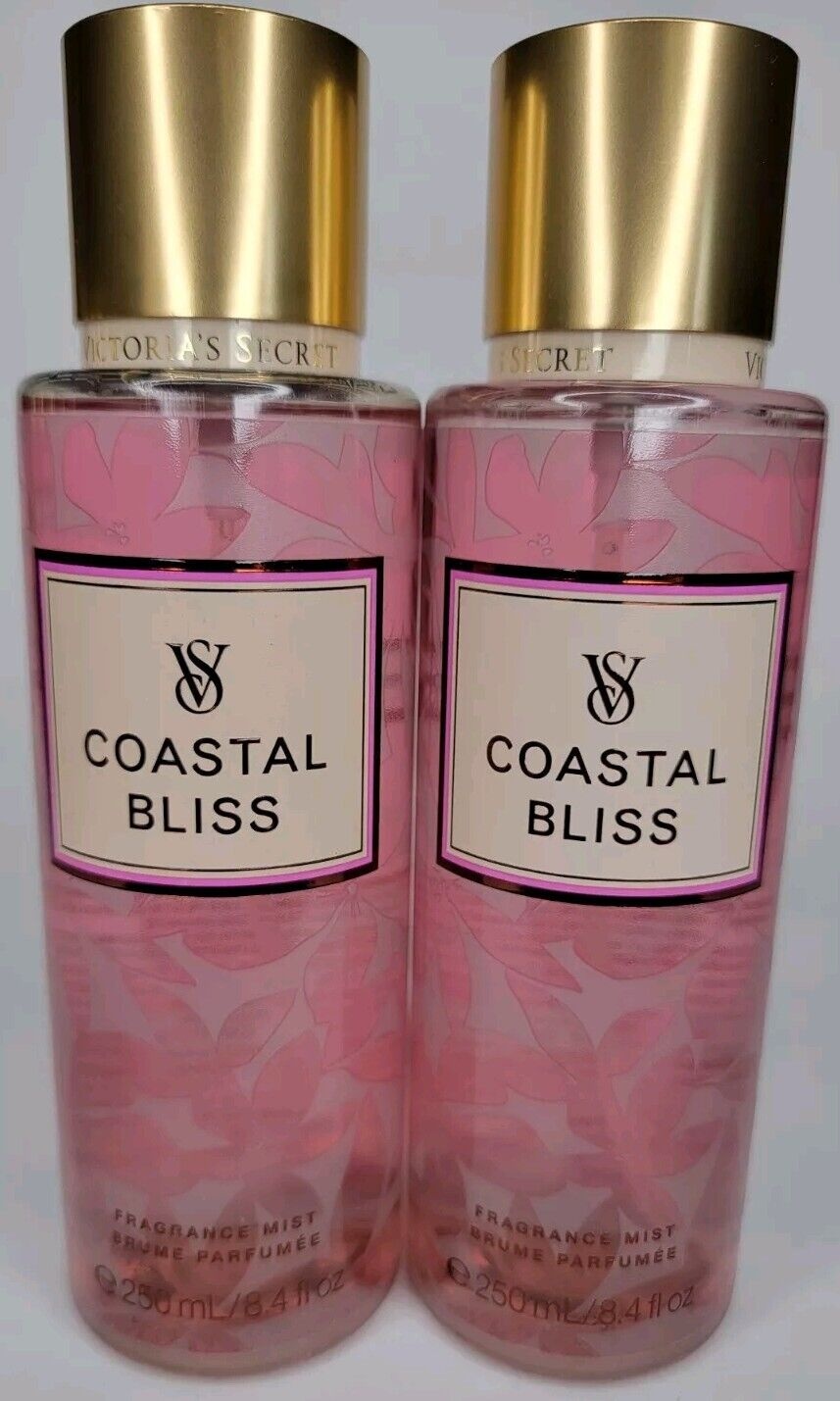Two 250ml bottles of Victoria's Secret Coastal Bliss Fragrance Mist, featuring a pink floral design, gold caps, and a prominent label with the product name.