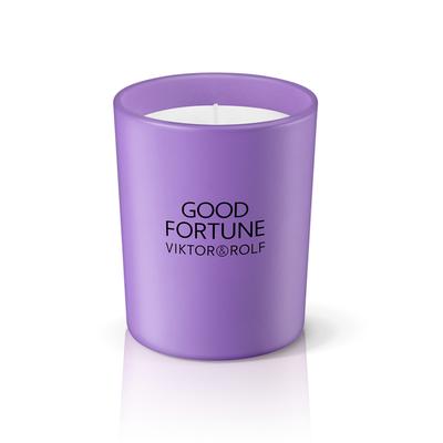 Purple glass candle holder with a white wax interior, featuring "GOOD FORTUNE VIKTOR&ROLF" printed in black on the front.