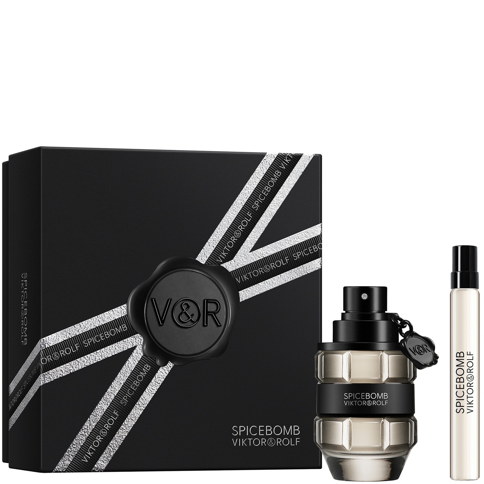 Black gift box with silver ribbon featuring a round seal, containing a 50ml glass fragrance bottle with a grenade shape and a 10ml travel-sized spray of Viktor & Rolf Spicebomb.