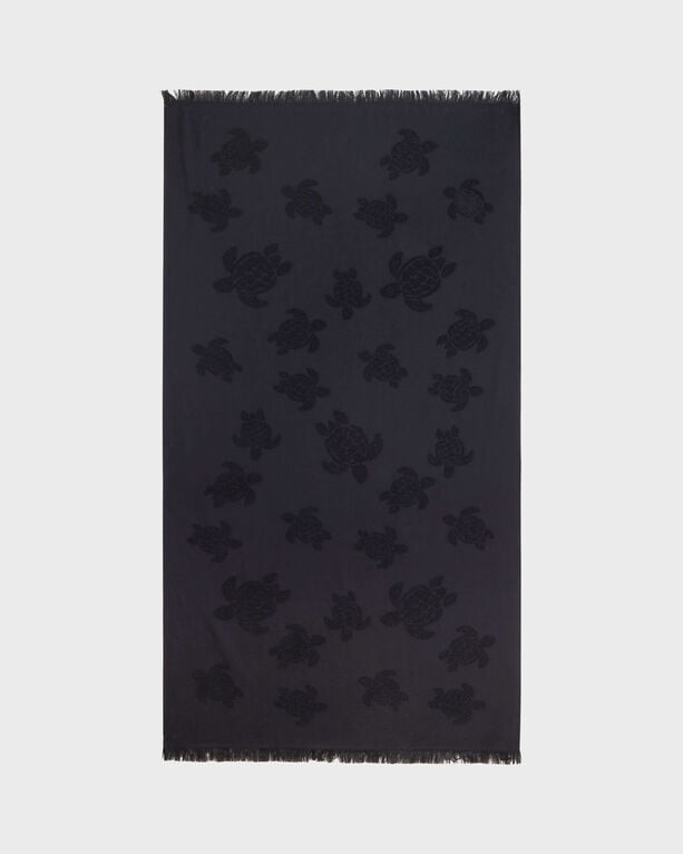 Black organic cotton beach towel featuring a jacquard design of turtles, with a fringed edge and a generous one-size-fits-all (OSFA) dimension.