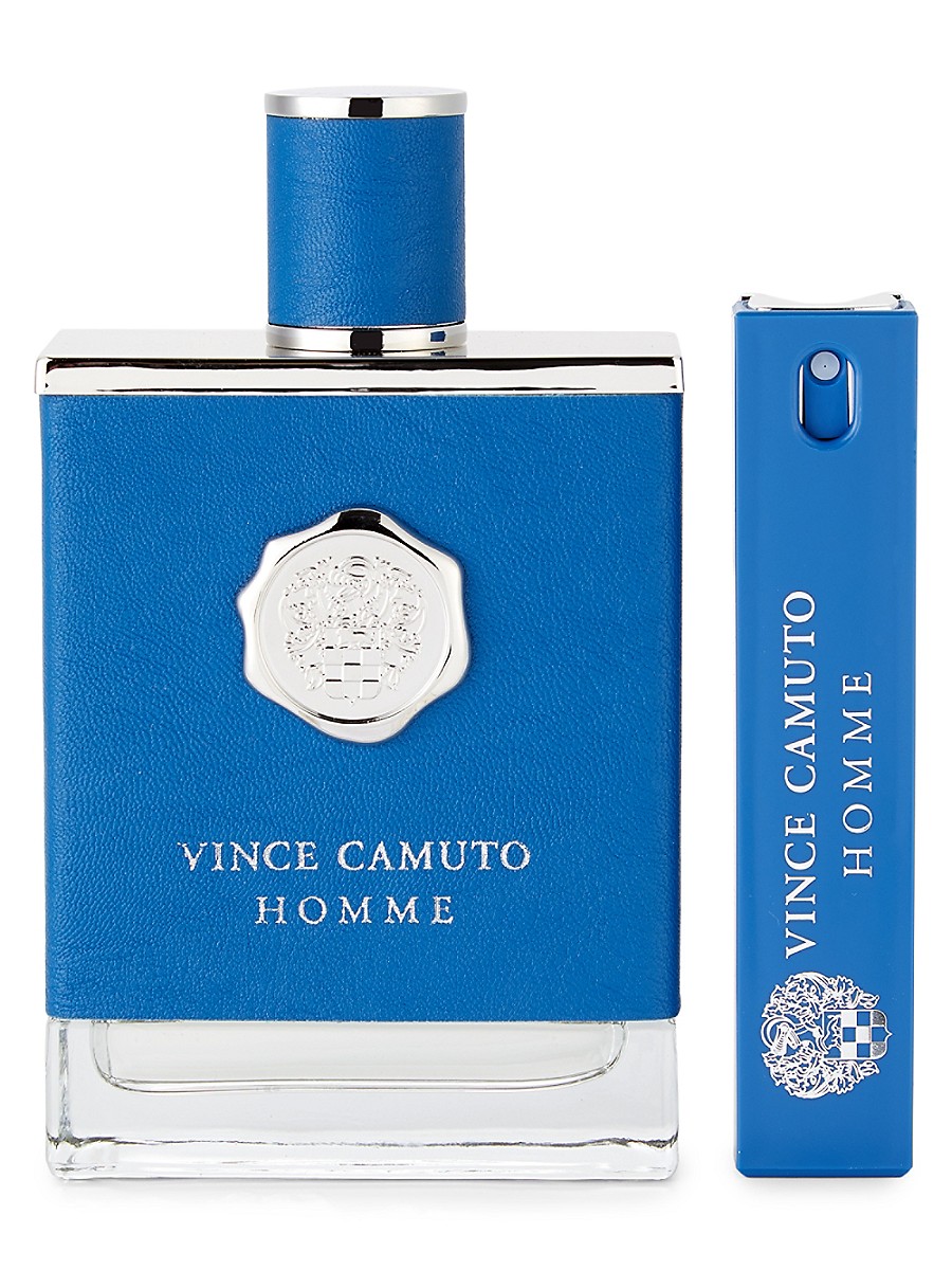 Blue glass bottle with a textured blue leather cap, silver accents, and a crest logo, accompanied by a smaller matching blue travel-sized EDT spray.
