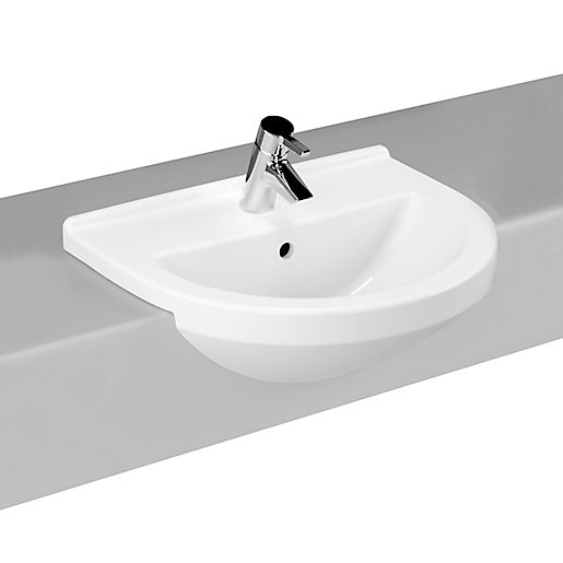 White ceramic semi-recessed basin with a round shape, featuring a single taphole and a sleek chrome faucet, mounted on a gray countertop.