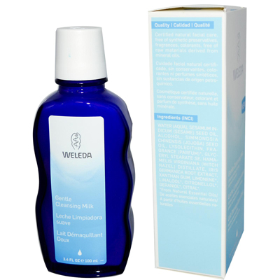 Blue plastic bottle with a curved shape, labeled "Weleda Gentle Cleansing Milk 3.4 Oz," alongside a light blue box displaying product details and ingredients.