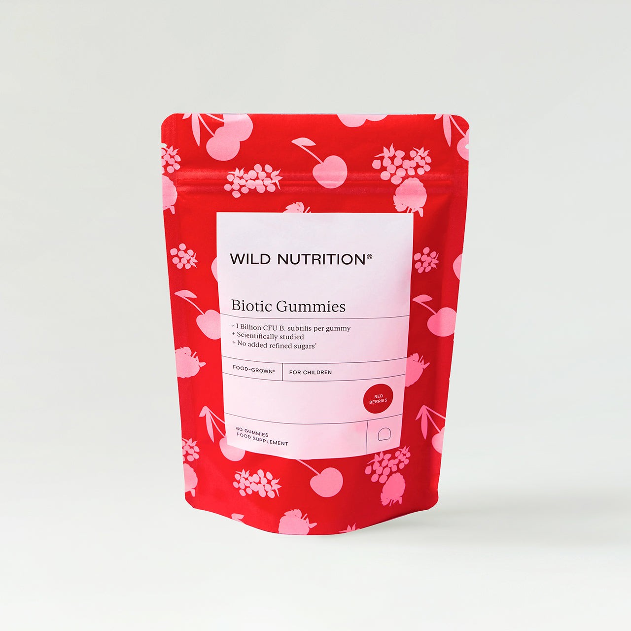 Bright red pouch featuring playful fruit illustrations, labeled "Wild Nutrition Biotic Gummies," with details on CFU and suitability for children, emphasizing a fun and appealing design.