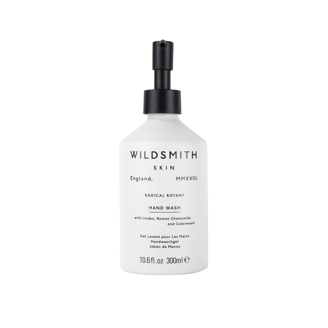 White aluminum bottle with a black pump, labeled "WILDSMITH SKIN HAND WASH," featuring a minimalist design and details about linden, chamomile, and cedarwood.