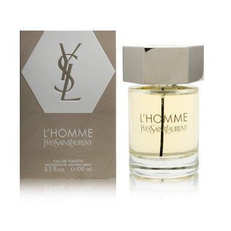 Clear glass bottle with a silver cap, featuring a hexagonal design, alongside a matching beige and silver box labeled "L'homme by Yves Saint Laurent," 3.3 oz Eau De Toilette for men.