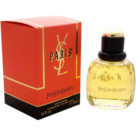 Clear glass bottle with a round shape, golden liquid inside, topped with a black cap, alongside a red and gold box featuring "YSL" and "PARIS" in elegant lettering.