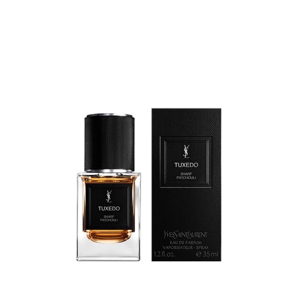 Clear glass bottle with a black textured cap, featuring a gold liquid inside, alongside a sleek black box with white text, labeled "TUXEDO" and "Yves Saint Laurent."