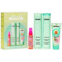 Amika haircare set with green bottles and colorful labels, includes shampoo, conditioner, and spray in a branded box.