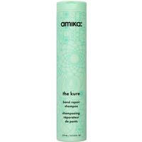 Amika The Kure Bond Repair Shampoo 275ml in a tall, mint green bottle with floral design and black text.