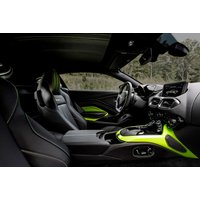 Black Aston Martin Vantage interior with neon green accents, sleek dashboard, and sporty bucket seats.