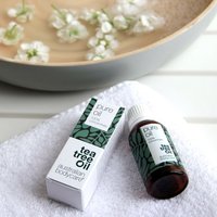 Australian Bodycare Pure Oil, 30 ml amber bottle with green leaf design, next to matching box on white towel.