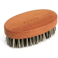 Oval bamboo beard brush by Mühle with natural bristles and engraved logo on wooden handle.