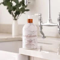 White marble-patterned Baylis & Harding hand wash bottle with copper pump, 500ml, on a bathroom counter.