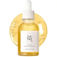 Beauty of Joseon Glow Serum bottle with white dropper, golden liquid, and circular backdrop of bubbly serum.