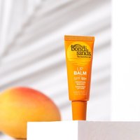 Orange Bondi Sands SPF 50+ Lip Balm tube with mango graphic, standing upright on white surface.