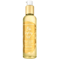 Clear bottle of Bumble and Bumble Bb. Styling Oil, 120 ml, with gold pump and white label detailing.