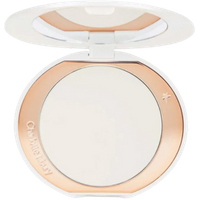 White compact with rose gold trim, containing Charlotte Tilbury brightening powder for fair to medium skin tones.