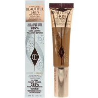 Charlotte Tilbury foundation tube in warm beige with rose gold cap, next to matching box with logo and text.