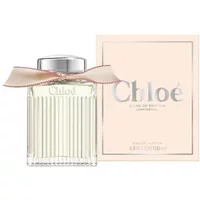Chloé L'Eau De Parfum Lumineuse 100ml bottle with ribbed glass, silver cap, and pink ribbon, next to matching box.