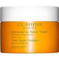 Clarins Tonic Sugar Polisher in a bright orange jar with a white lid, labeled for body exfoliation with essential oils.