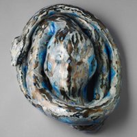 Sculptural ceramic piece with swirling dark blue, black, and gray marbled patterns, resembling a coiled form.