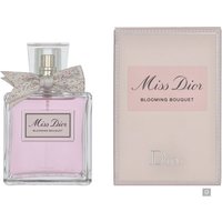 Clear glass bottle of Dior Miss Dior Blooming Bouquet Eau de Toilette with pink liquid and a silver bow, next to pink box.