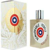 Clear glass bottle with silver cap, featuring a circular logo. White box with gold accents and artistic design.