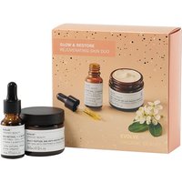 Evolve Beauty skincare set with amber dropper bottle, cream jar, and peach speckled box featuring floral design.