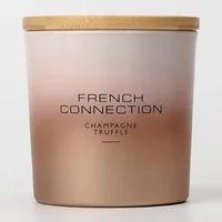 Metallic champagne truffle candle in gradient gold jar with wooden lid, French Connection branding.