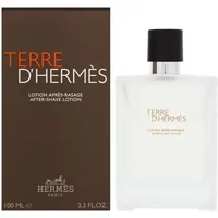 Clear glass bottle with black cap, labeled "Terre D'Hermes Aftershave Lotion," next to brown box packaging.