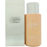 Peach-colored Jean Paul Gaultier Classique body lotion bottle with silver cap next to matching branded box.
