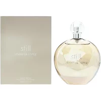 Clear round bottle of Jennifer Lopez Still Eau De Parfum 100ml with a silver cap, next to a beige box.